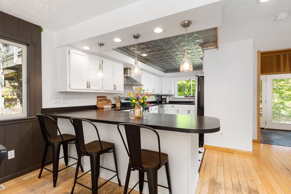 Modern kitchen island w/ barstools & stylish lighting for casual breakfasts