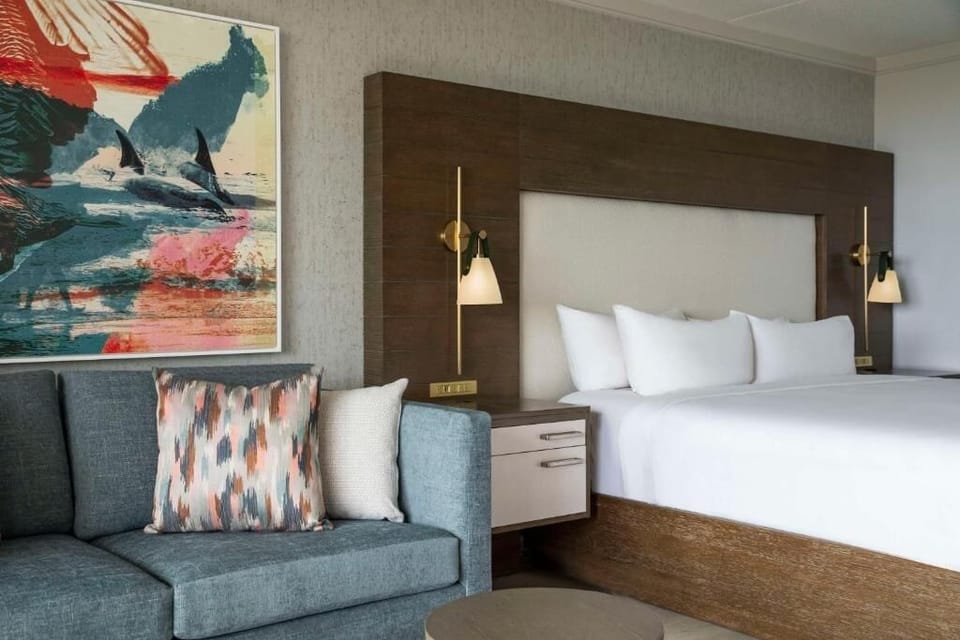 Sink into plush bedding beside artful décor and soft lighting.
