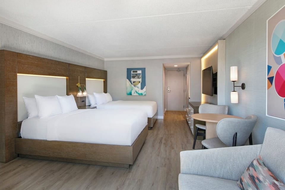 Unwind in a modern double-queen retreat with cozy lounge area.