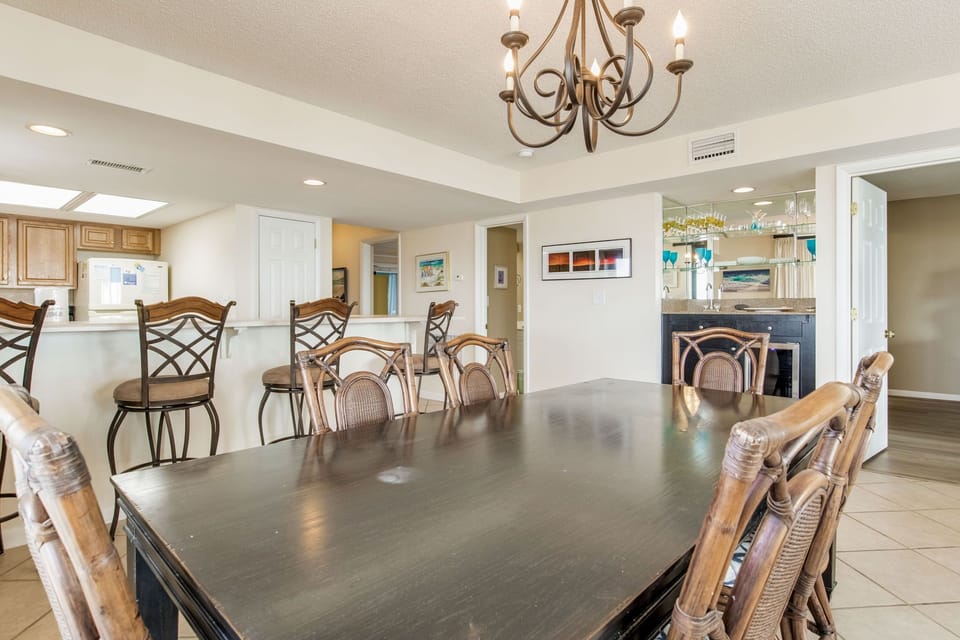 Elegant dining space with chandelier and seating for eight at Wind Drift 112 SW Orange Beach beachfront condo