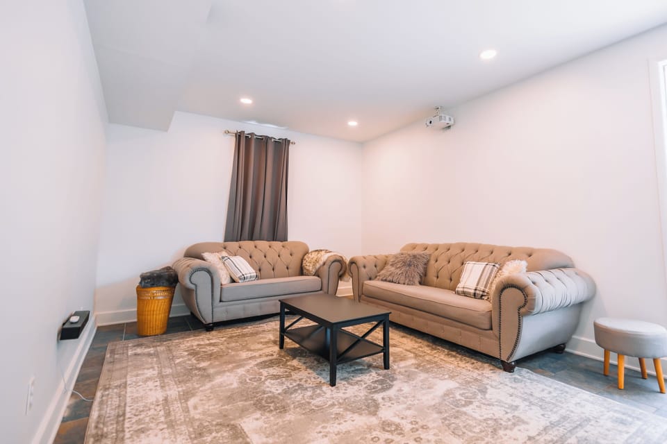 Spacious living room with 100" projector, bose sound, streaming, & large sofas.