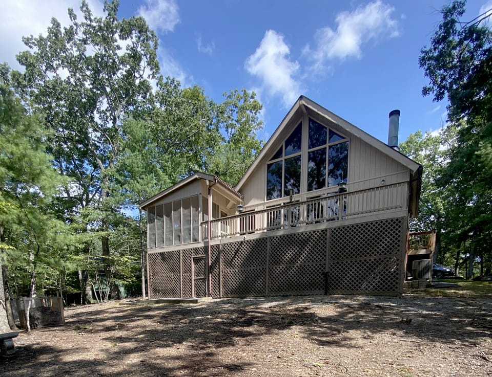 Full glass open living area with cathedral ceilings, lots of light and privacy