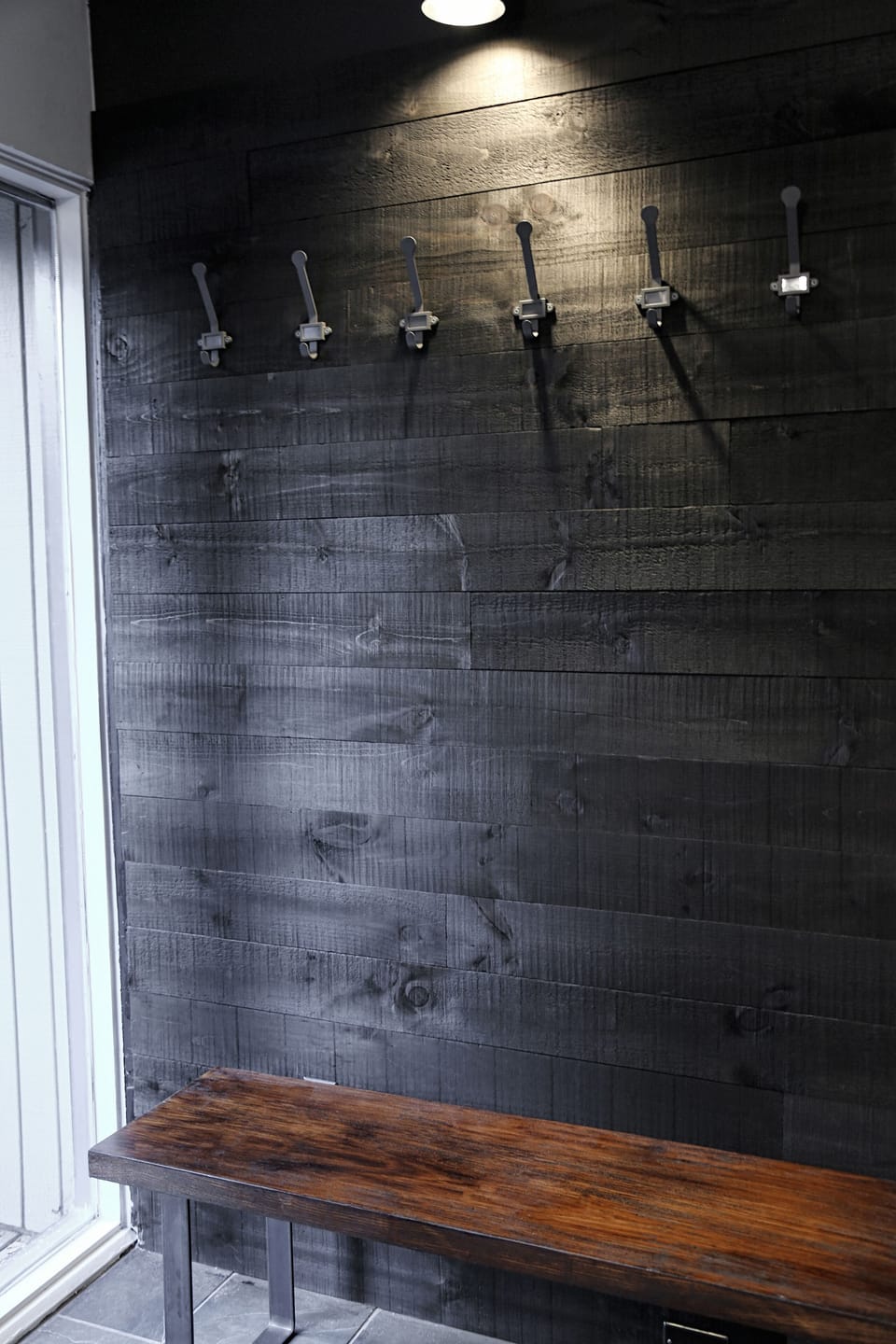 Coat hooks over wooden bench at Entryway