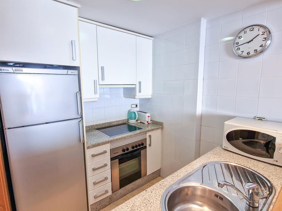 Kitchen with serving hatch connected to the living/dining room, allowing light to circulate and giving direct access to prepared dishes at mealtimes.