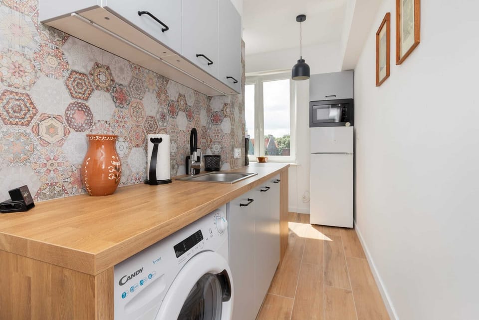 A fully equipped kitchen with a stylish backsplash depicting historic industrial imagery.