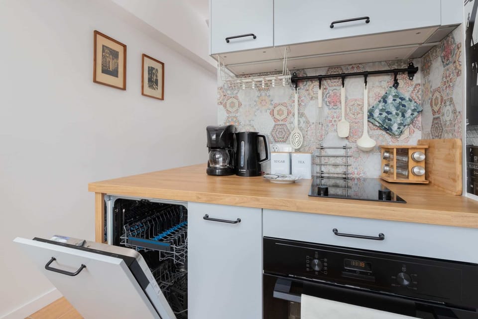 A fully equipped kitchen with a stylish backsplash depicting historic industrial imagery.