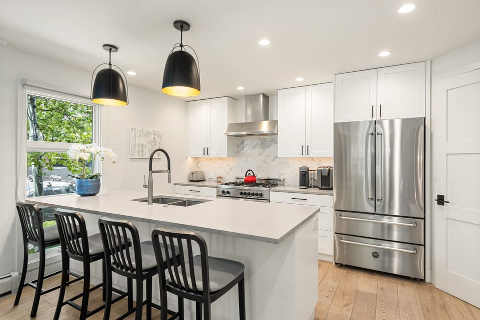 Modern, sleek kitchen with top-of-the-line appliances and four-top bar seating.