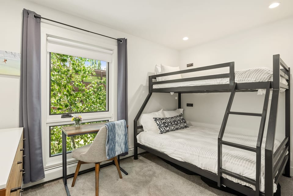 Guest bedroom with twin-over-full bunk bed, 60" cable TV, and closet