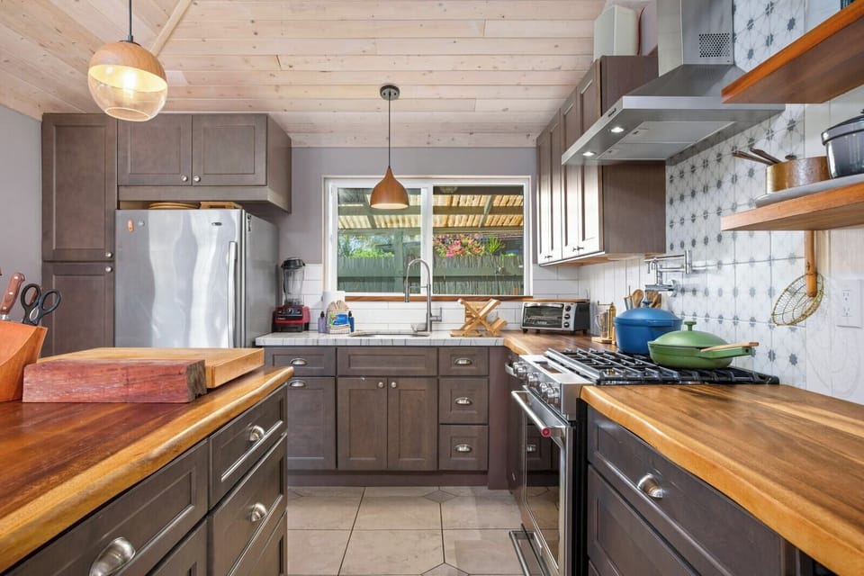 Bathed in honeyed light and framed by whispering foliage, this kitchen is a quiet symphony of nature and nurture combined   