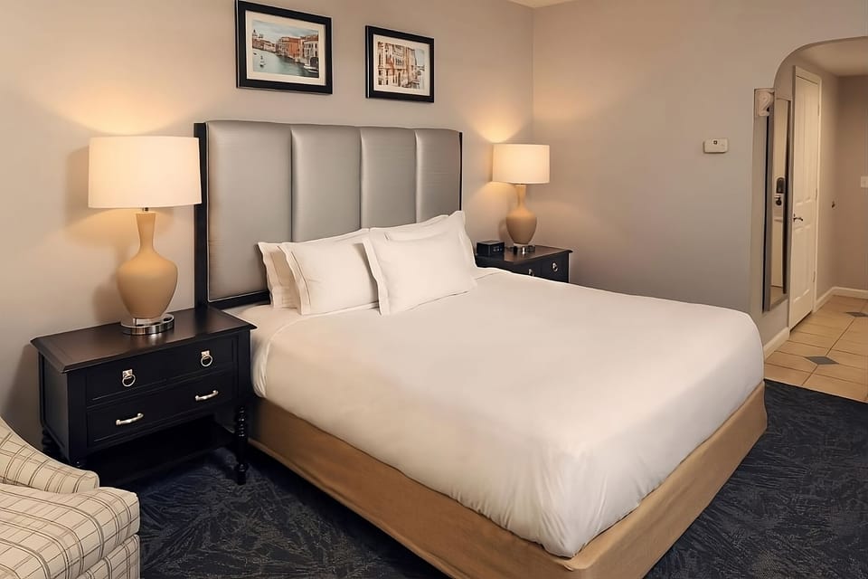 Unwind in crisp linens with soft lamplight and calm décor.