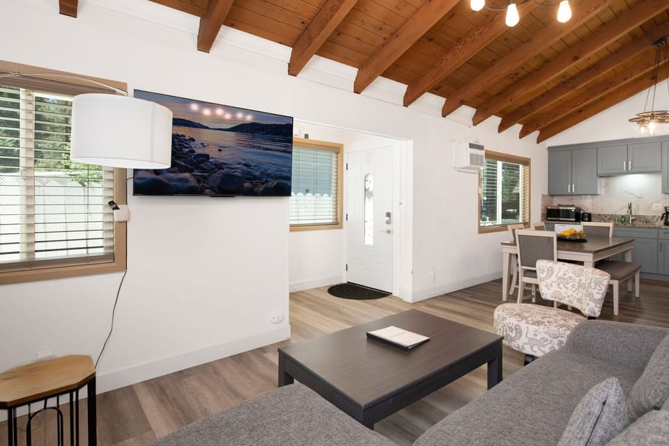 Cozy mountain living room with a stone fireplace, comfy seating, and smart TV—perfect for relaxing evenings, movie nights, and warm cabin vibes after outdoor adventures.