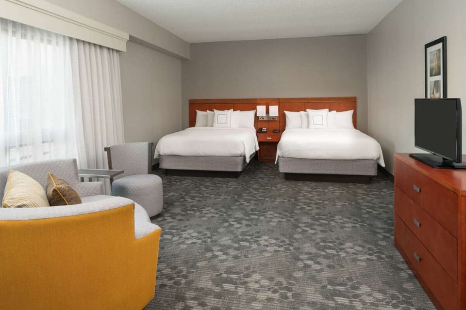 Unwind in a spacious double-queen room with cozy seating.