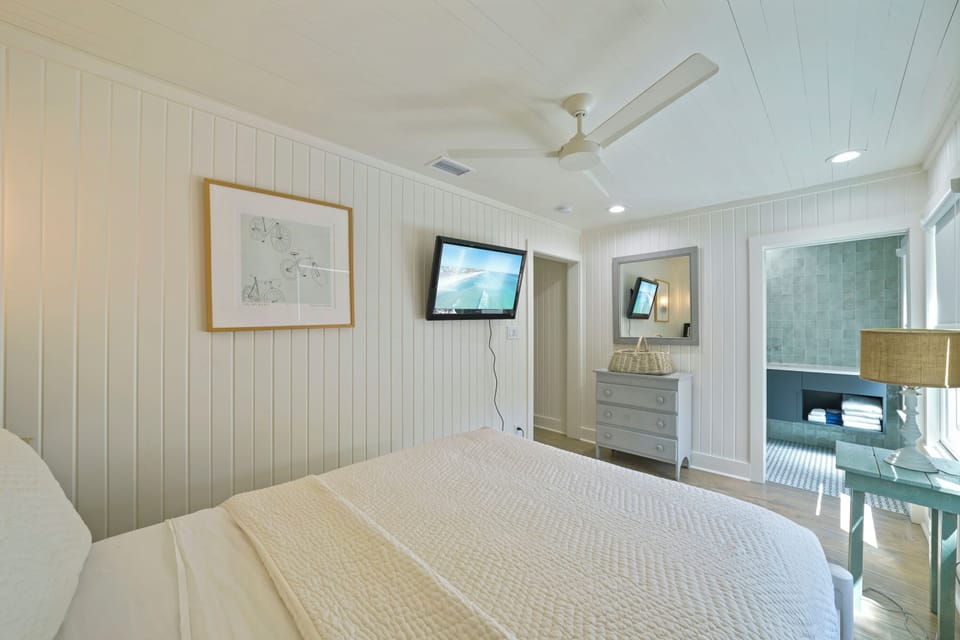QUEEN ROOM WITH MOUNTED FLATSCREEN, DRESSER, NEXT TO FULL BATH