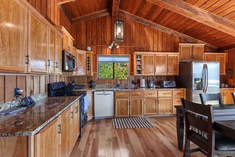 Beautiful kitchen with custom cabinets hardwood flooring and stainless-steel appliances