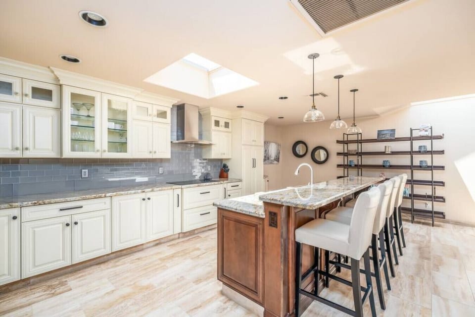 Gourmet kitchen with expansive island, skylights, and custom cabinetry.