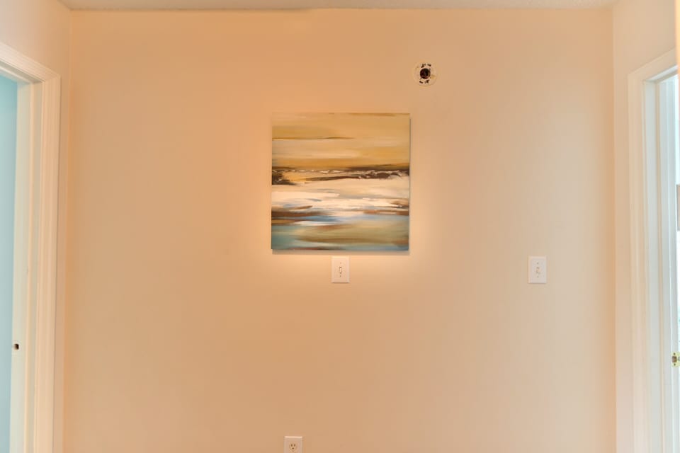 Wall-mounted beach art on soft neutral background