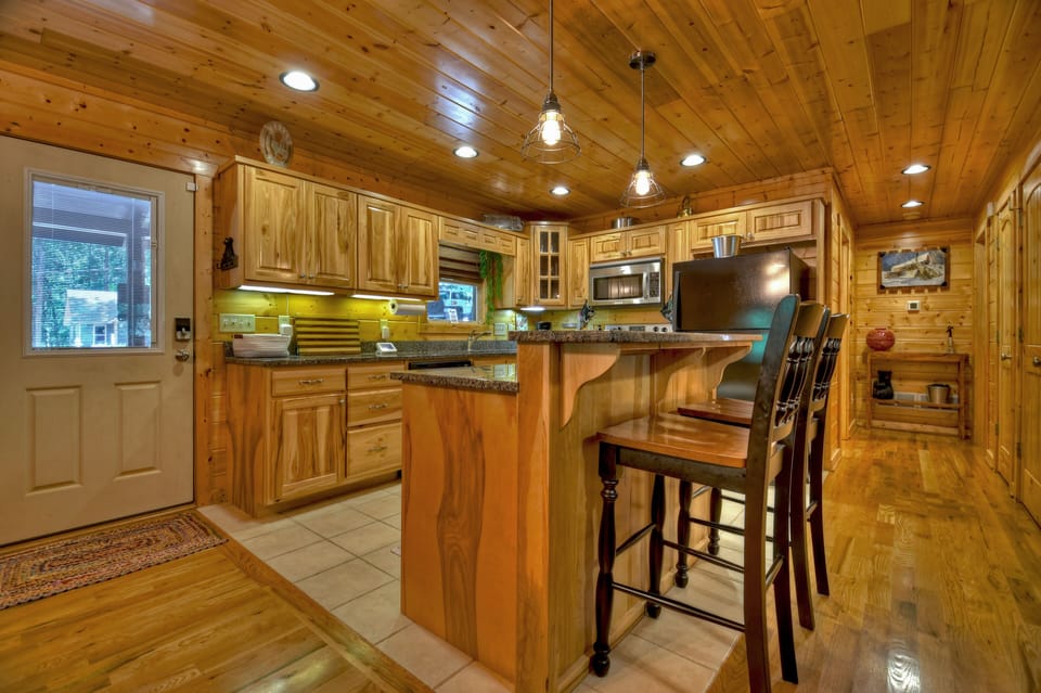 Kitchen island with bar seating and forest views from window 