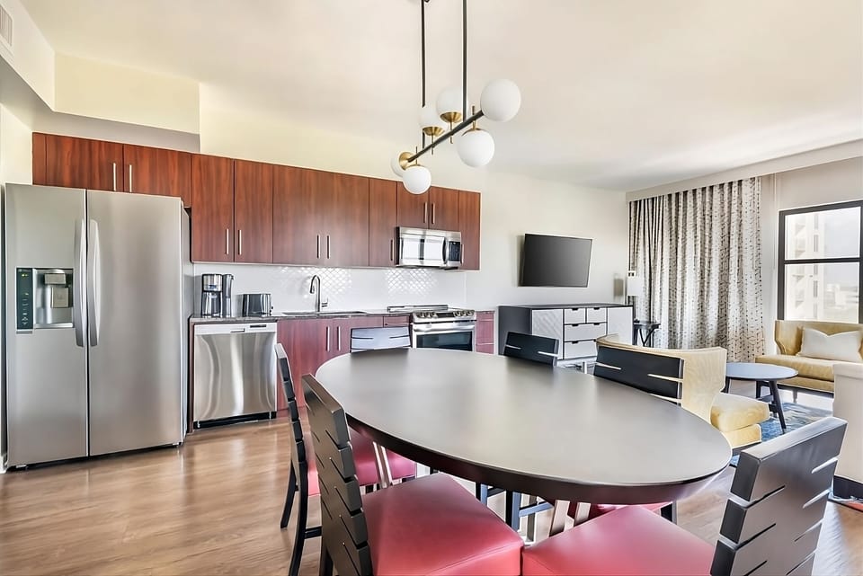 Gather for meals in an open kitchen-dining space, sunlit and airy.
