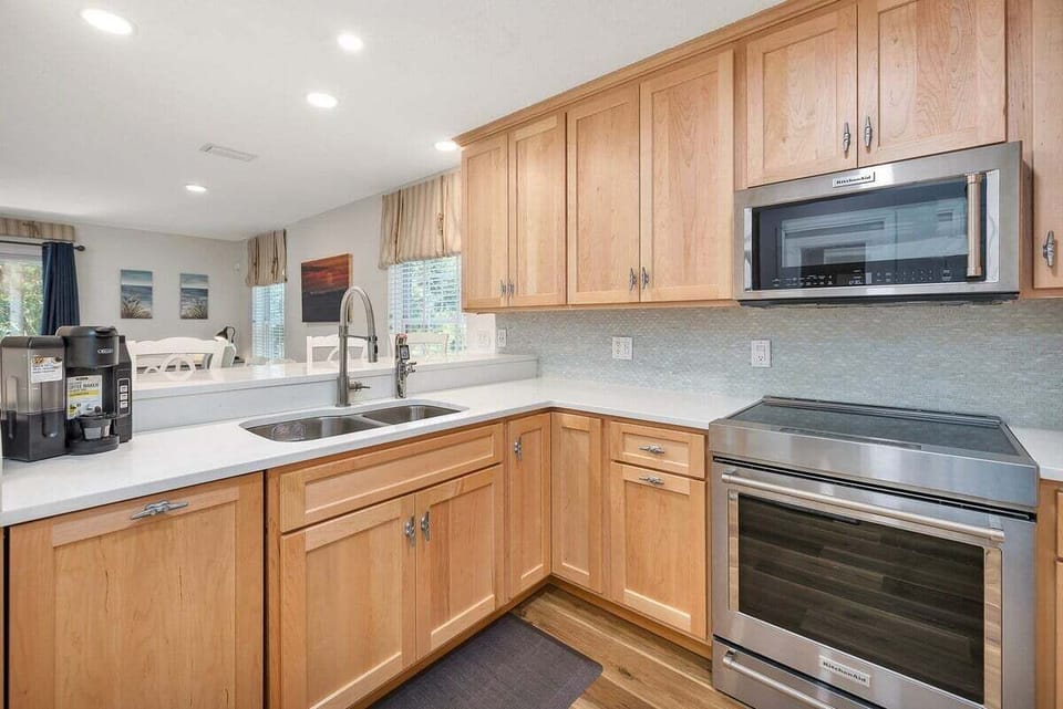 Wood kitchen with stainless appliances and white counters