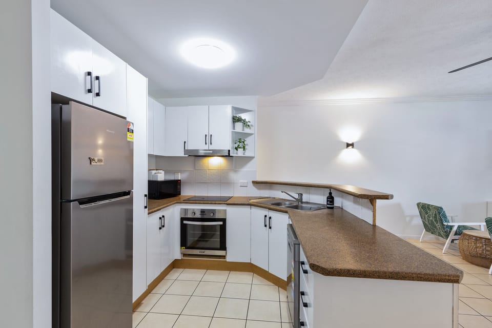 Kitchen with fridge, microwave, toaster, kettle and oven. 