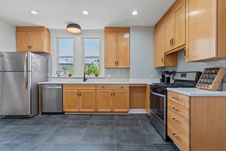 Bright, fully equipped kitchen with stainless steel appliances and ample counter space—perfect for cooking at home or hosting meals together.