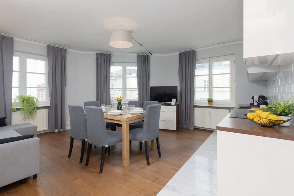 A combined dining and living area, featuring stylish gray chairs and tasteful decor.
