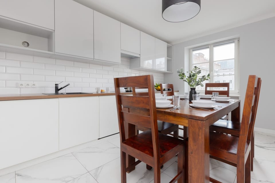 A warm and inviting dining space adjacent to the kitchen, complete with wooden furniture and a view of the outside.