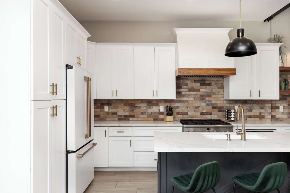 Kitchen with stone backsplash, barstool island seating