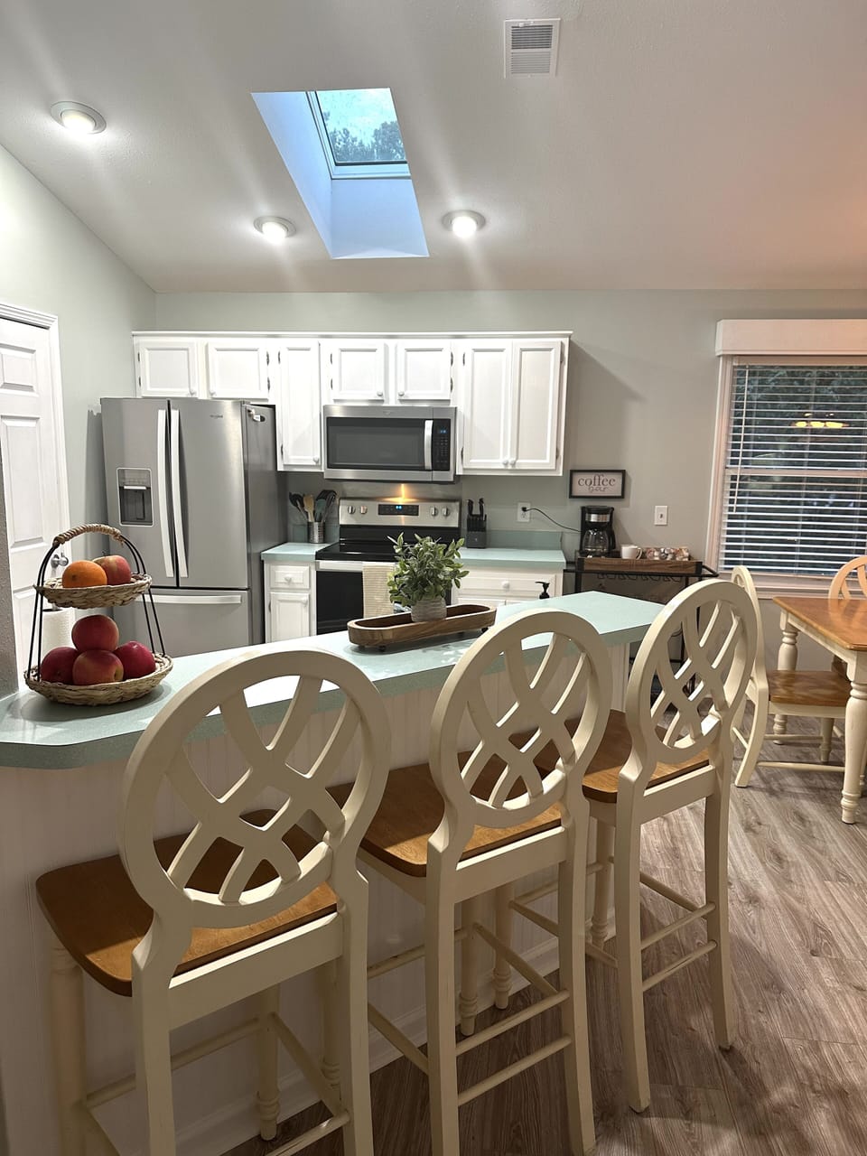 Full kitchen with updated stainless steel appliances and a coffee/cocktail cart