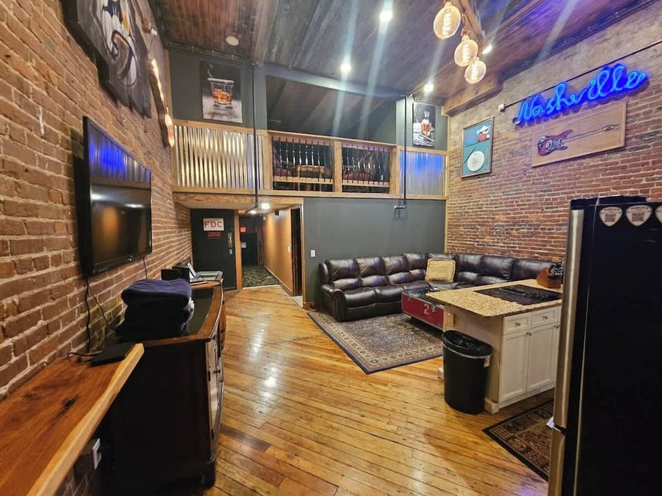 Spacious living room with vaulted 16' ceiling. Seating areas features plush, powered recliningleather wrap around couch with ample seating. Wall decor features signed album and memorabilia from world-class artists. 1973 Rockola Jukebox with 100 45's.