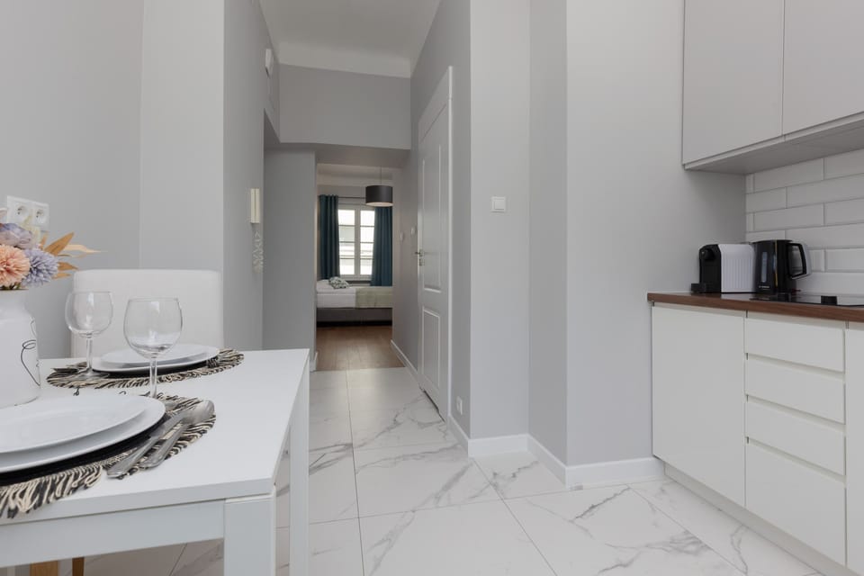 The bright and airy dining corner features a small table set with minimalist decor, perfectly positioned near the window for natural light.