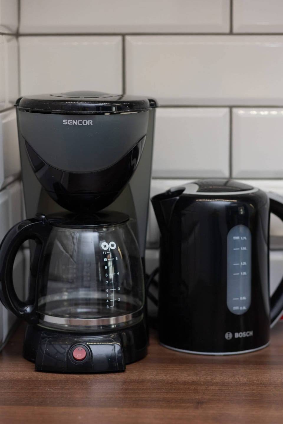 A neatly arranged countertop displays a coffee maker, kettle, and toaster, ensuring convenience for everyday use.