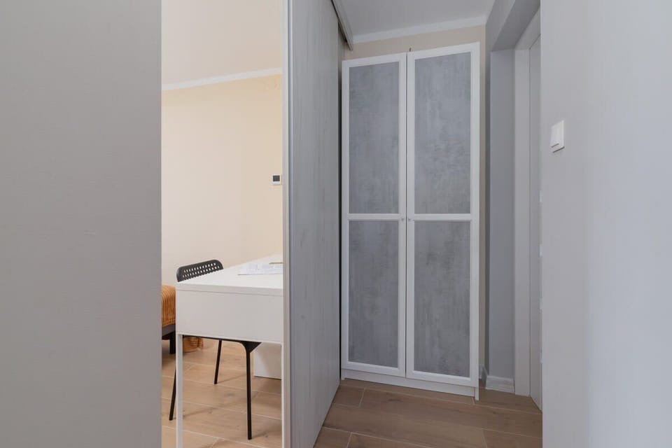A hallway featuring a built-in wardrobe with sliding doors, maximizing space and storage.






