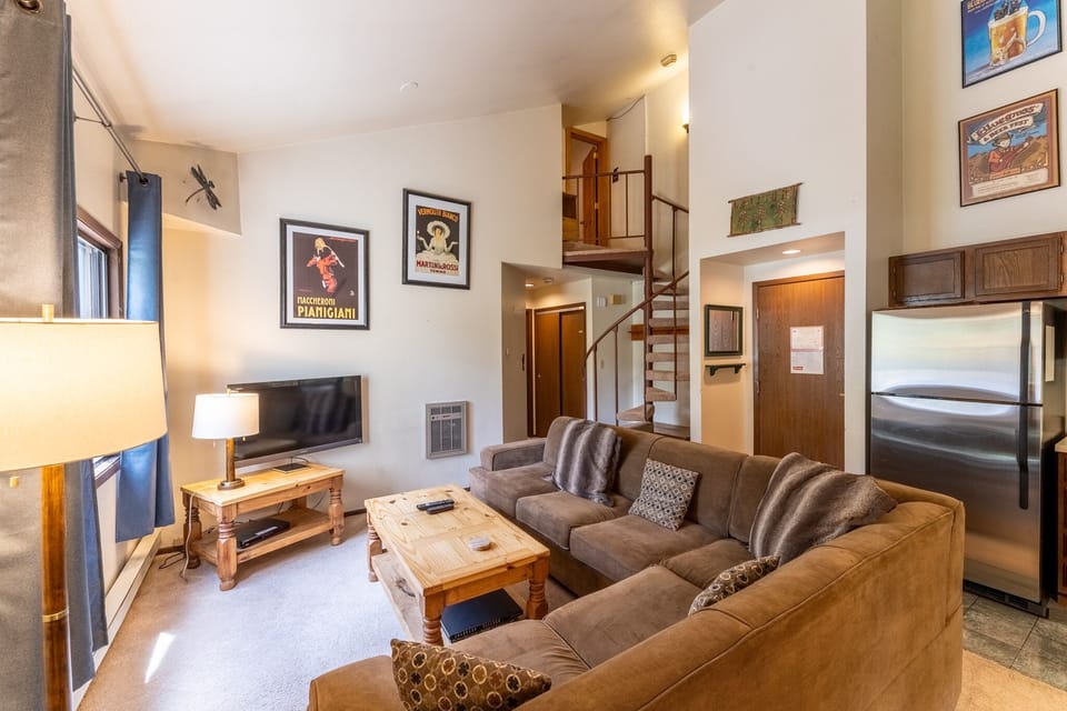 Living area offering cozy furnishings, a gas fireplace and vaulted ceilings.