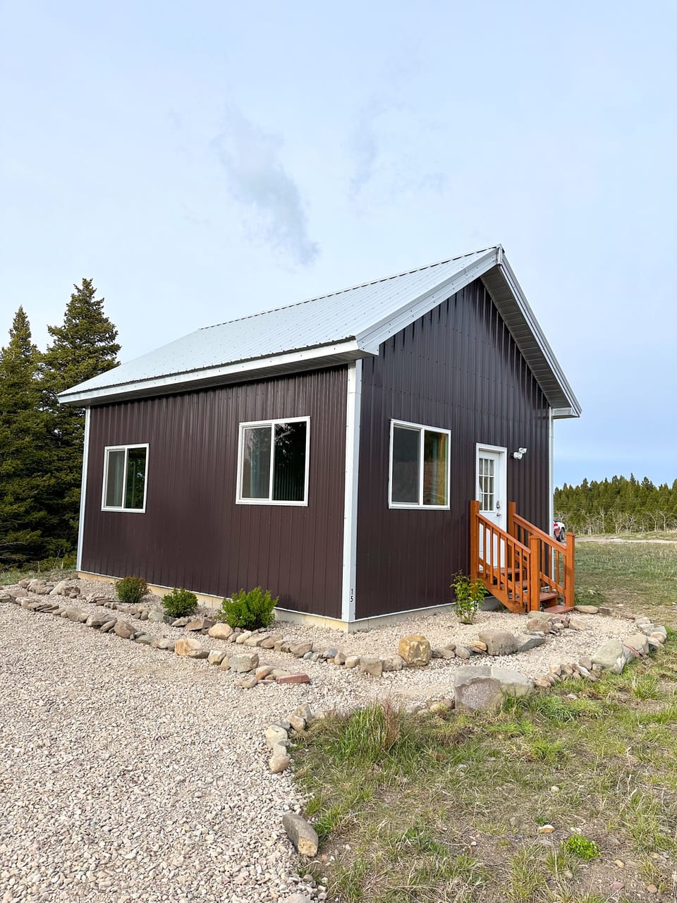 View of the front/side of the cabin and parking area. 