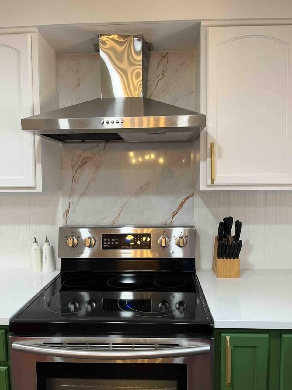 Unit 2: Kitchen with over range hood and electric stove.