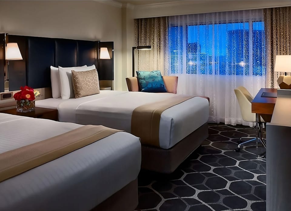 Settle into crisp double beds with city views and warm lighting.