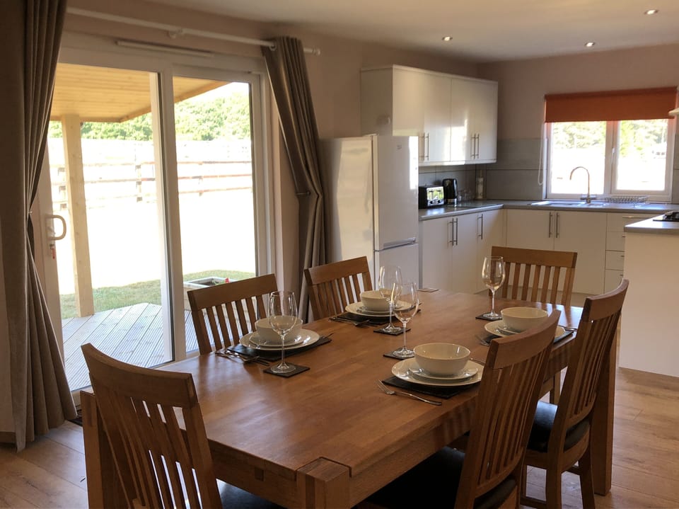 Large dining table for the four guests with kitchen in the background.