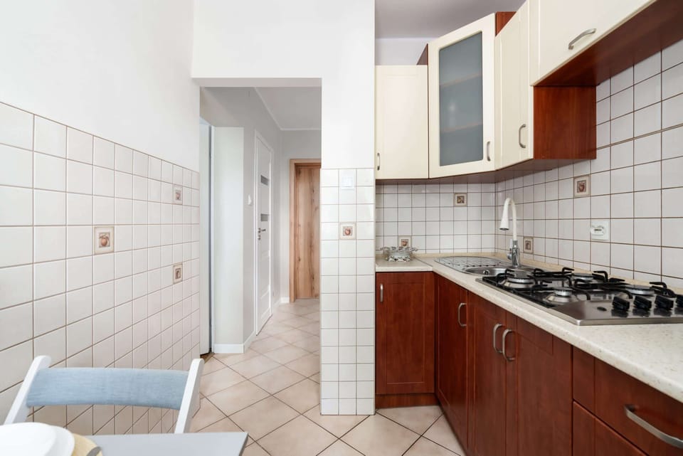 A fully equipped kitchen with white and wooden cabinets, offering a practical space for meal preparation.
