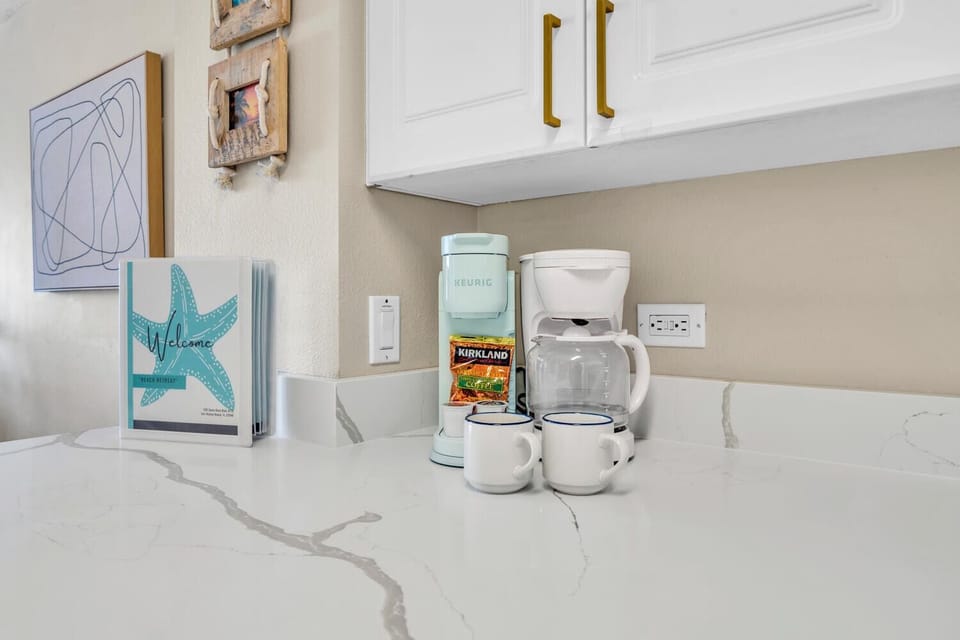 Start your mornings right with complimentary coffee and tea, perfectly set up for your convenience in this charming coastal-themed kitchen.