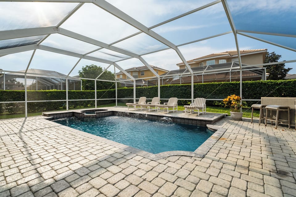 Beautiful paver stone lined deck with pool and spa.