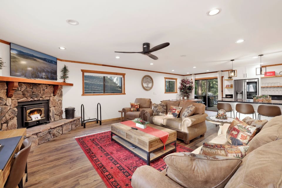 Inviting living room with stone fireplace, plush seating, and warm décor. Perfect for cozy nights, streaming your favorite shows, or relaxing by the fire.