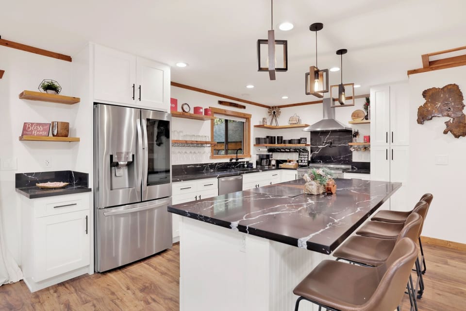 Fully equipped kitchen with stainless steel appliances, large island, and bar seating. Designed for cooking, entertaining, and gathering with ease.