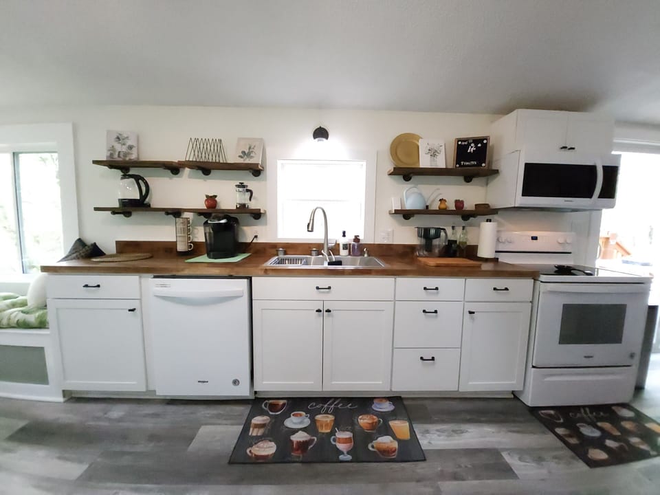 Full kitchen stocked with cooking basics, dining sets, and coffee