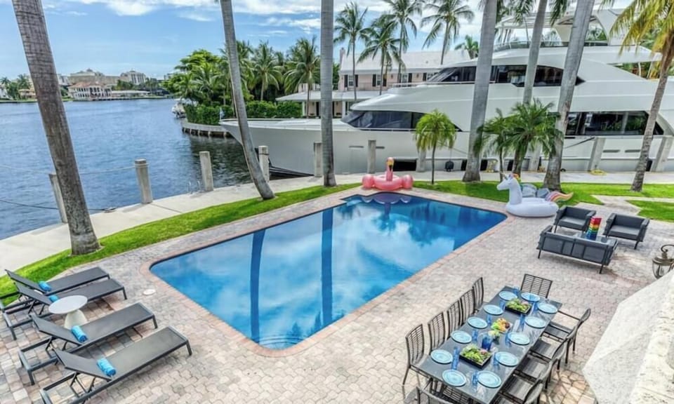 Outdoor waterfront Point Lot with pool area with outdoor dining, lounge chairs, BBQ & siting area. 