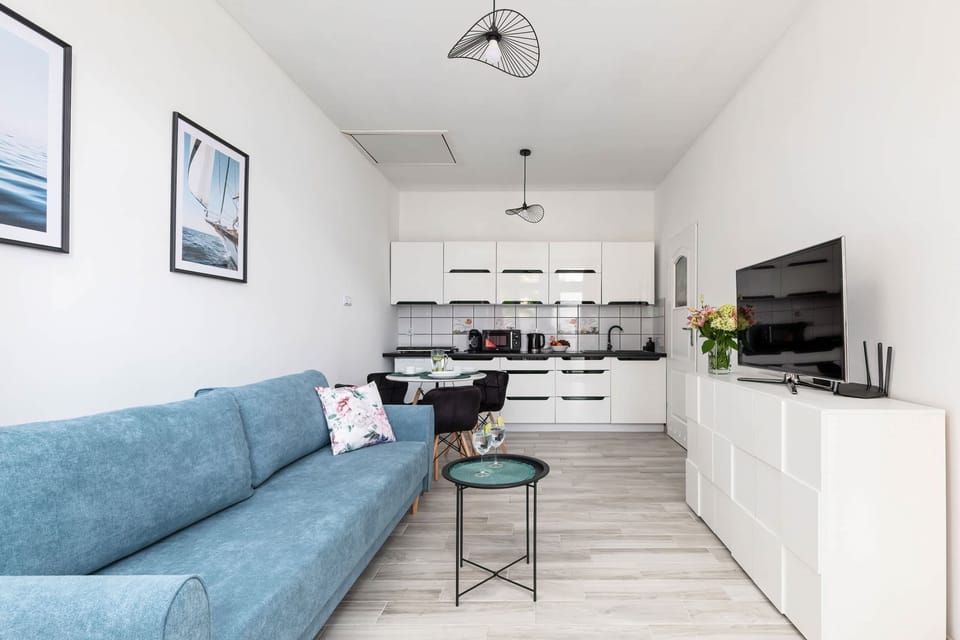 A well-lit living and dining area with a spacious layout and minimalistic furnishings.


