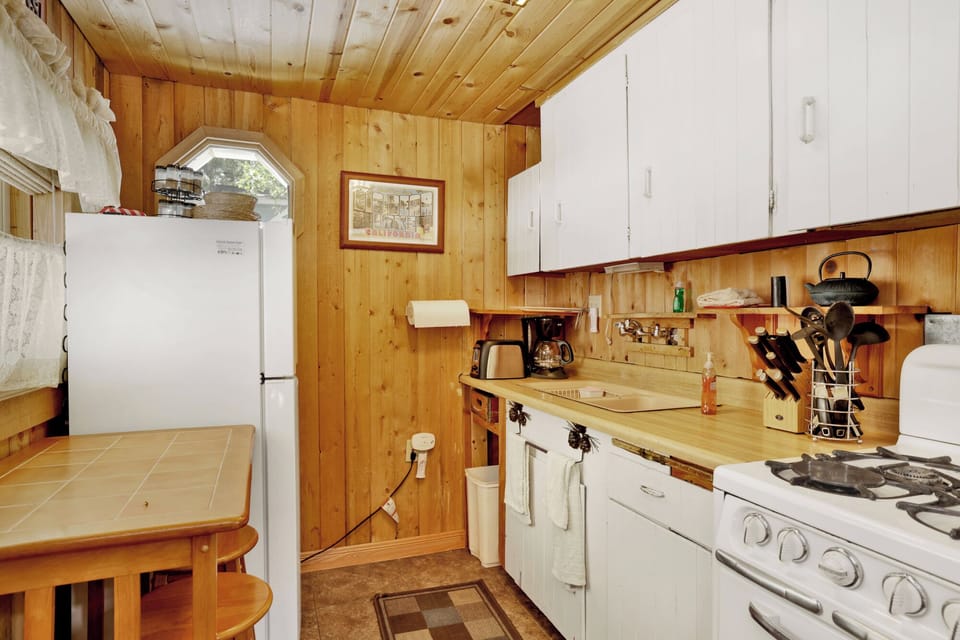 Fully equipped cabin kitchen with ample cabinetry, stove, fridge, and coffee maker—perfect for cooking meals, morning coffee, and feeling right at home during your stay.