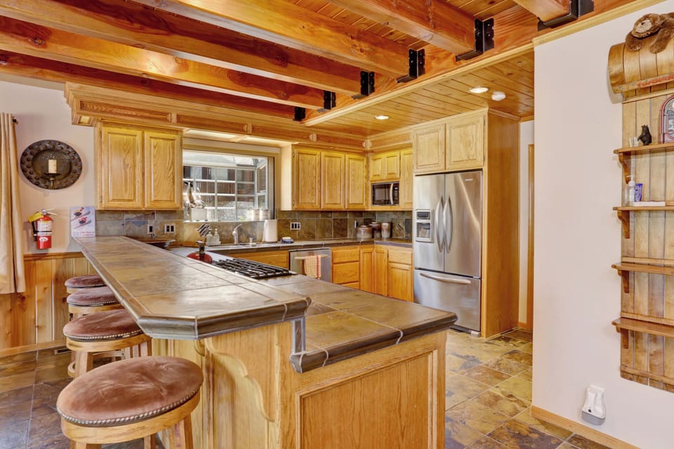 Fully equipped cabin kitchen with ample cabinetry, stove, fridge, and coffee maker—perfect for cooking meals, morning coffee, and feeling right at home on your stay.
