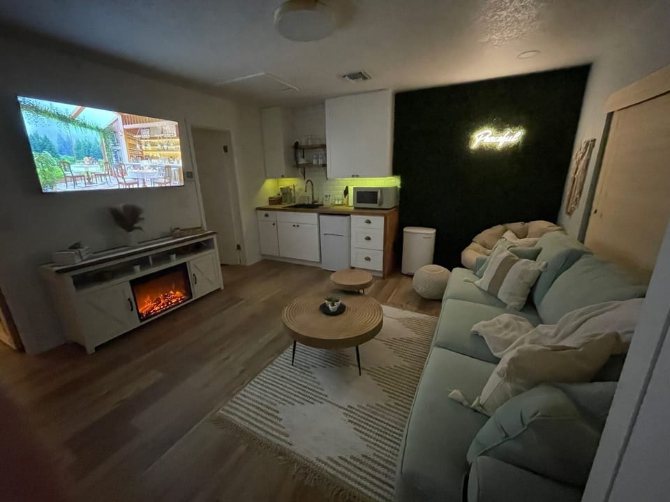 Night time with fireplace and kitchen lighting.