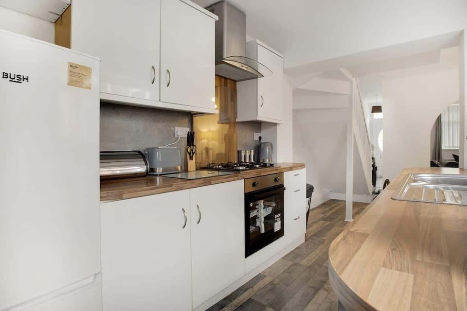 Kitchen equipped with all essentials, including an oven, stovetop, fridge, kettle, and toaster.